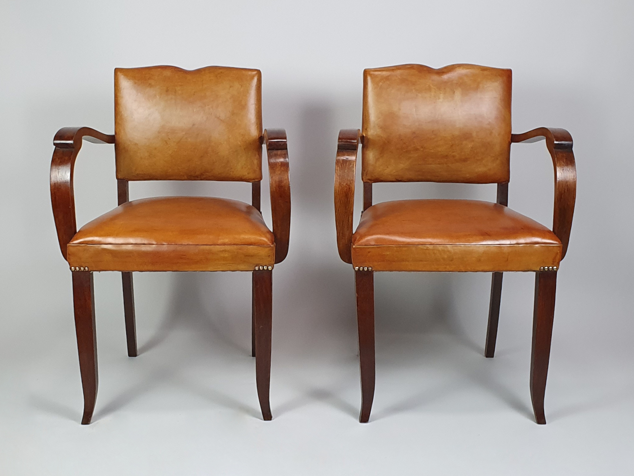 Pair of French leather moustache bridge chairs