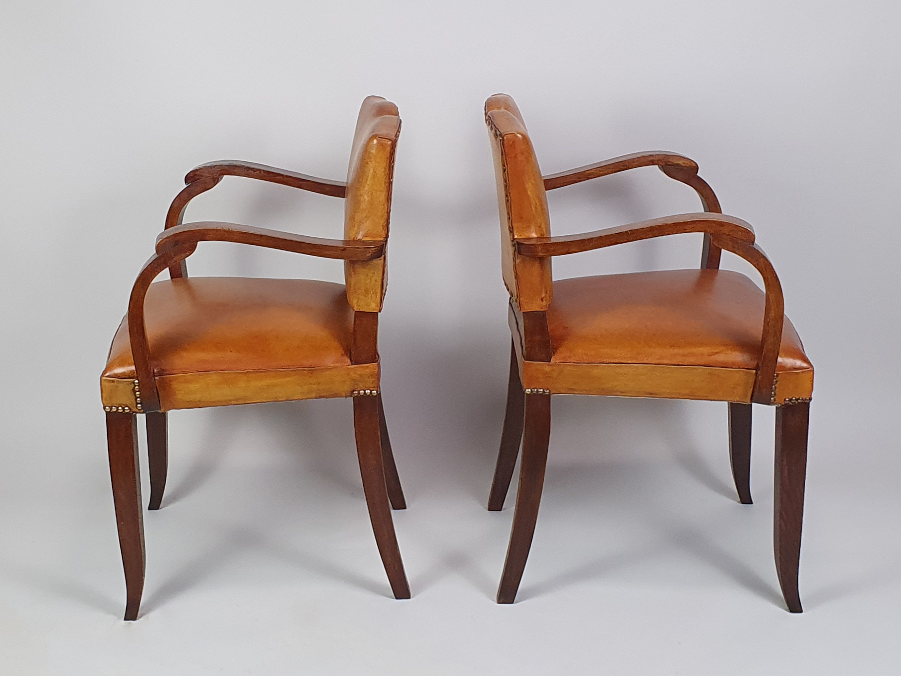 Pair of French leather moustache bridge chairs