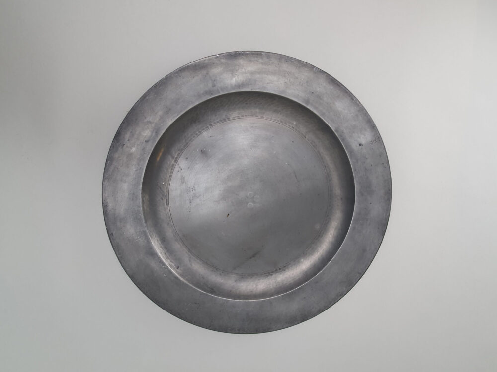 A large antique Georgian 18th century pewter Charger with and beaten detailing