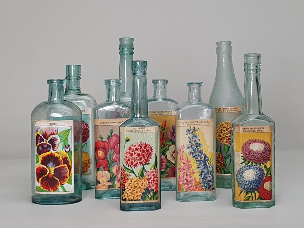 Collection of decorative antique bottles with old French flower labels