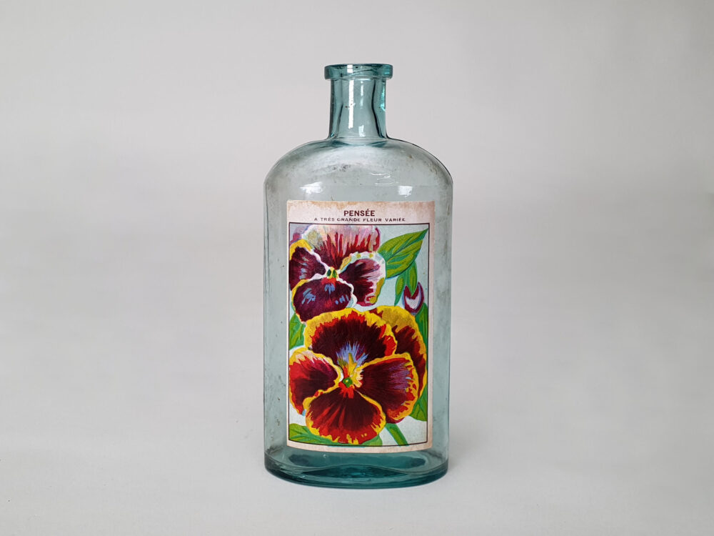 Collection of decorative antique bottles with old French flower labels