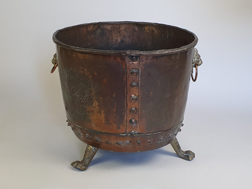 Large rivetted Copper Log Basket with lions head handles and raised paw feet