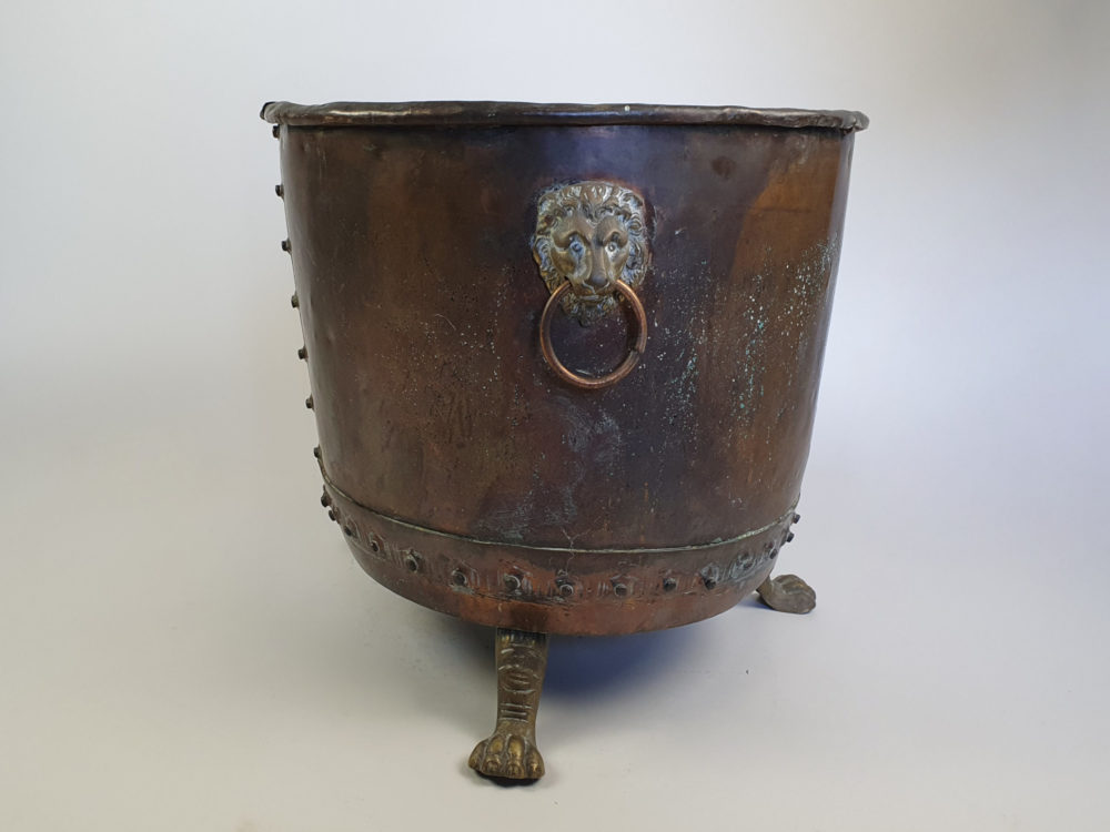 Large rivetted Copper Log Basket with lions head handles and raised paw feet