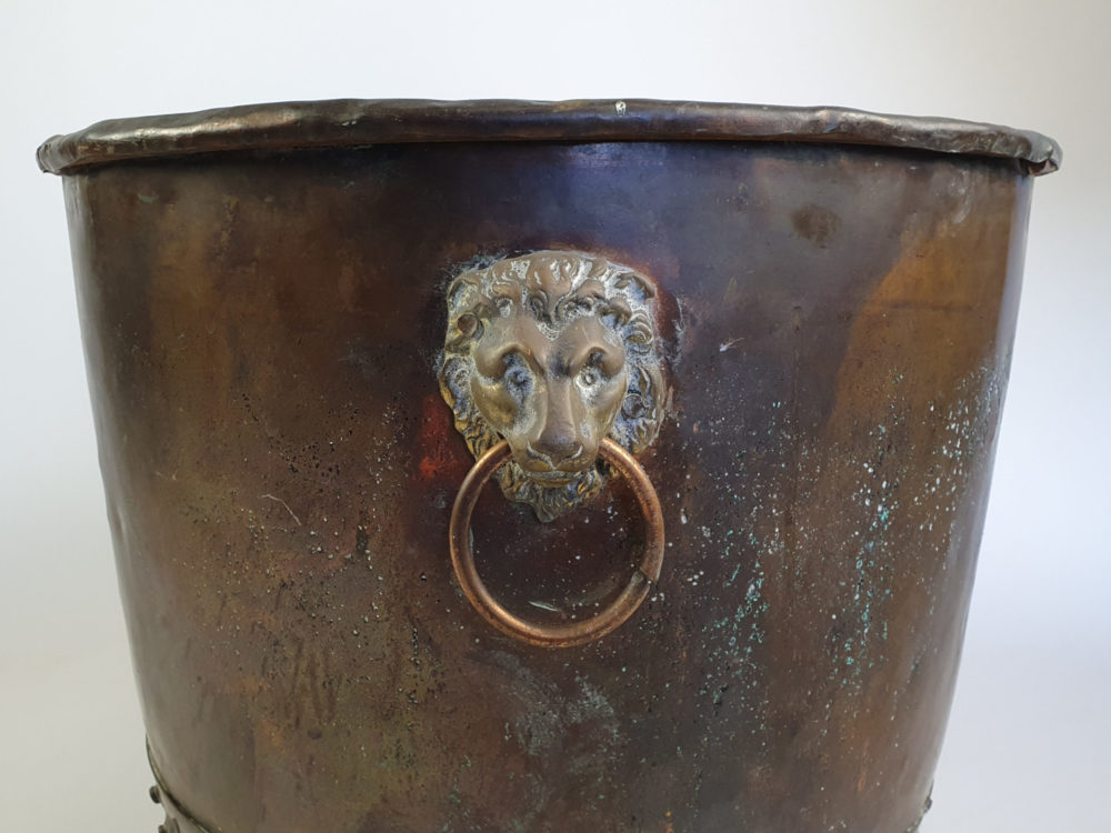 Large rivetted Copper Log Basket with lions head handles and raised paw feet