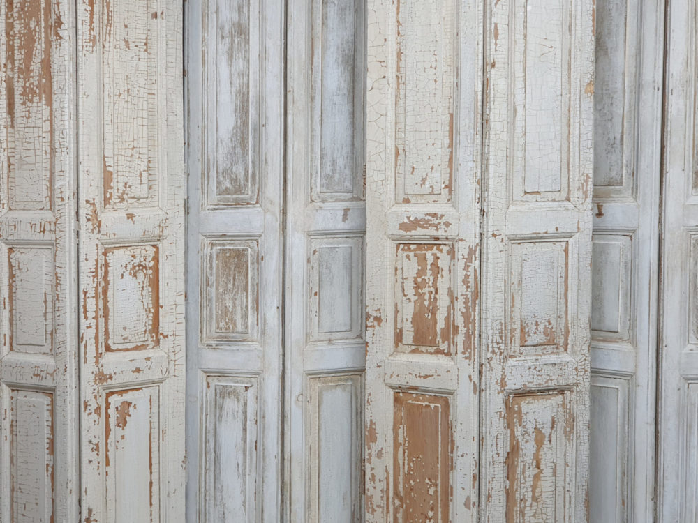 Two pairs of tall panelled antique Shutters in original cream paint