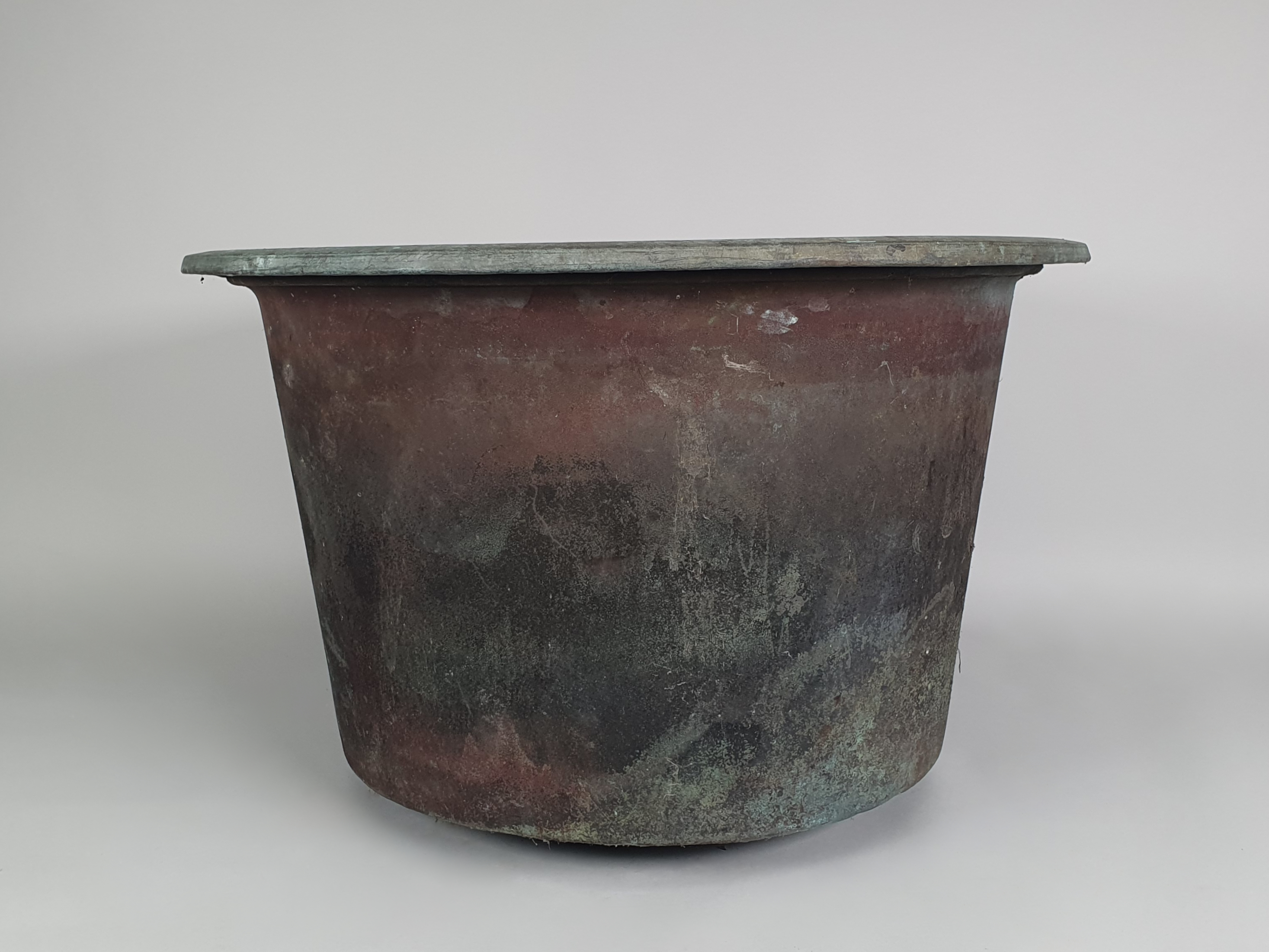 A pair of large garden antique copper planters wide shot