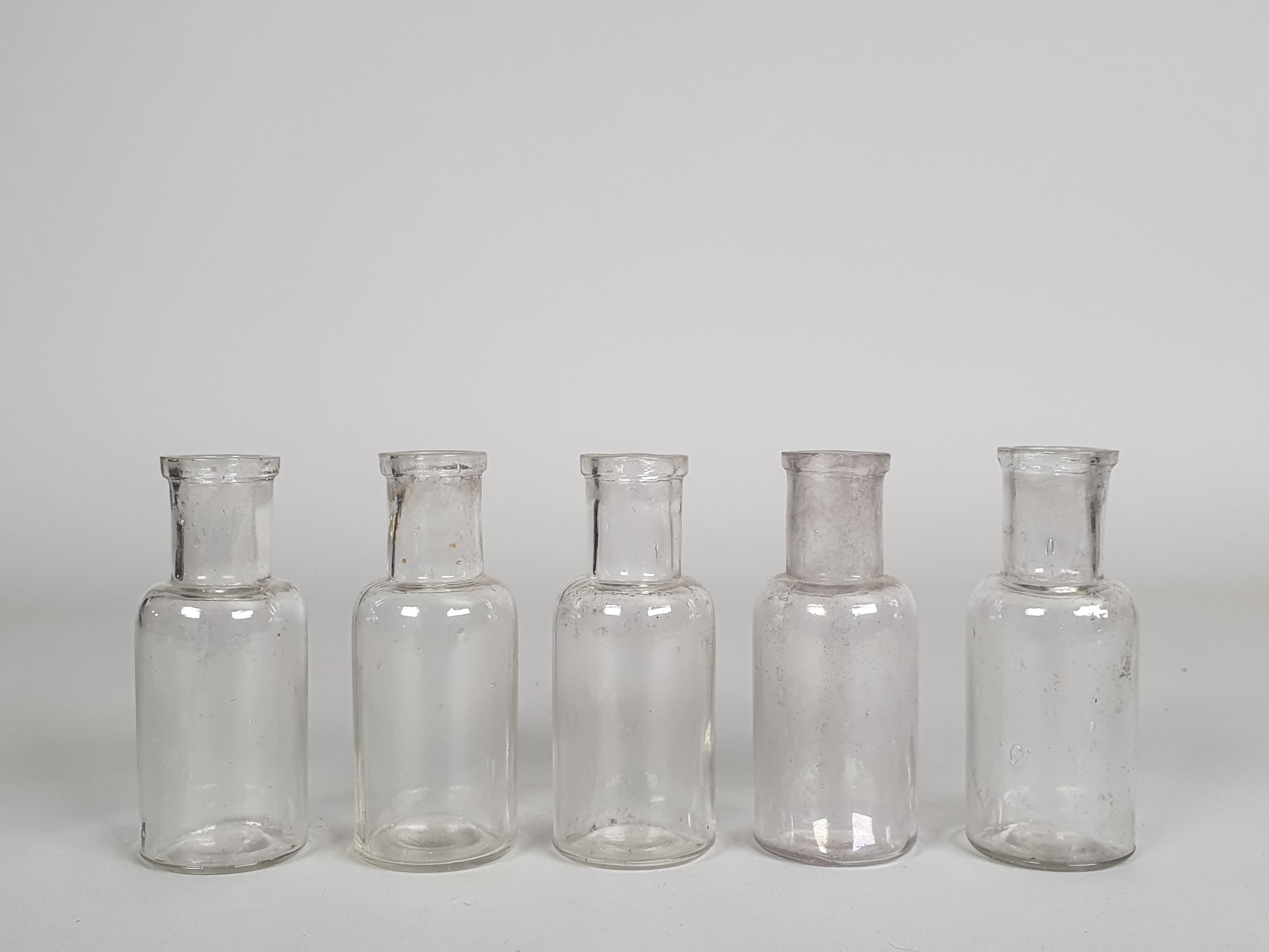 Collection of 100 small antique glass apothecary bottles